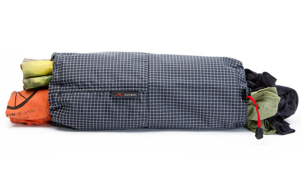 A Travel Laundry Stuff Sack with clean clothes in one side and dirty clothes in the other.